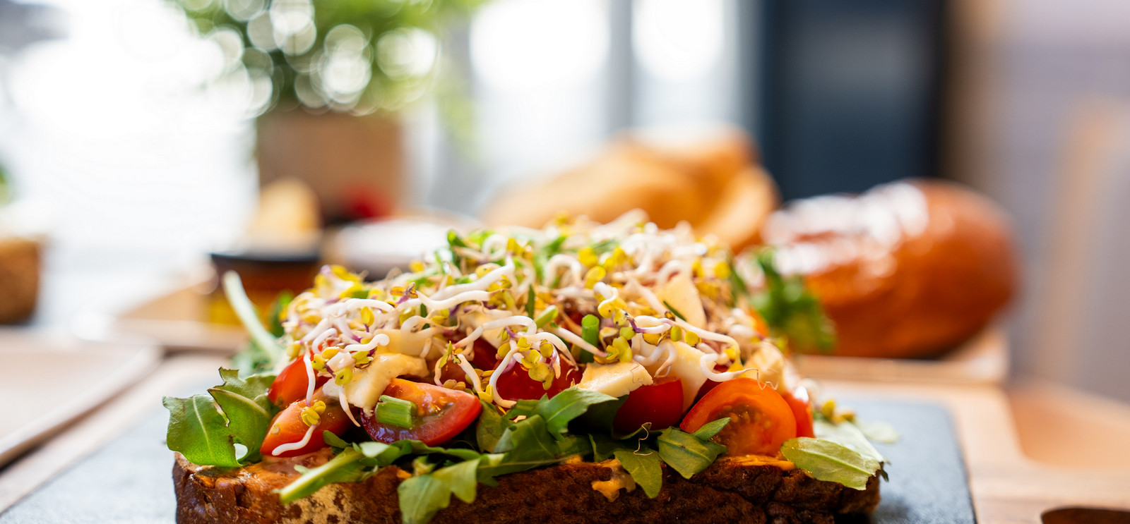 Belegtes Vollkornbrot mit Rucola, Tomaten und Sprossen – Frühstück Brotzeit Rostock